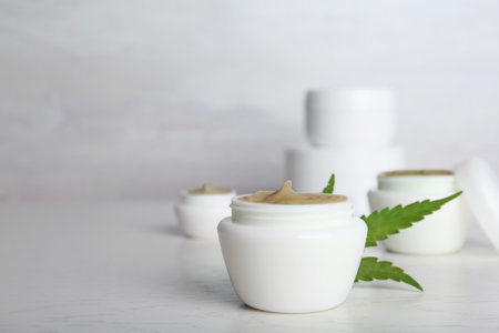 Plastic jar with hemp lotion on tableの写真素材