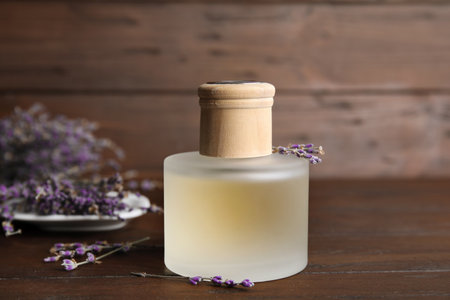 Bottle with aromatic lavender oil on wooden table