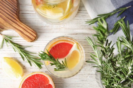 Flat lay composition with grapefruit and rosemary cocktail on light tableの写真素材