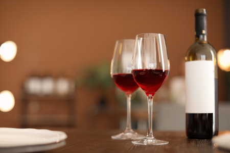 Glasses and bottle with tasty wine on table in restaurantの写真素材