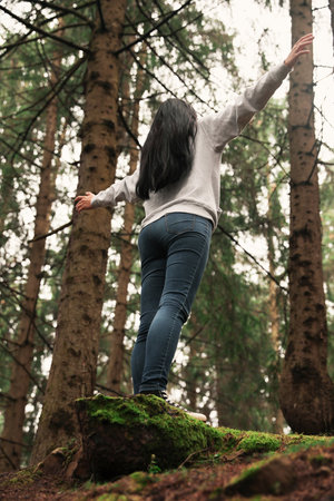 Woman on walk in beautiful coniferous forest