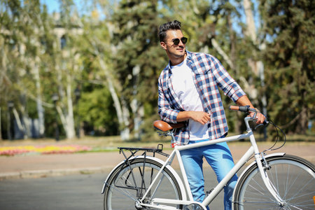 Handsome young hipster man with bicycle outdoorsの写真素材