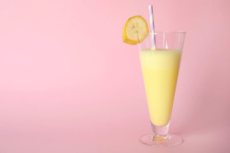 Glass of tasty milk shake and space for text on color backgroundの写真素材