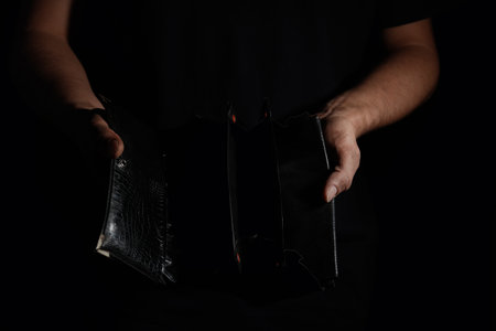 Poor man with empty wallet on dark background, closeupの写真素材