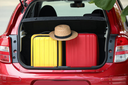 Suitcases and hat in car trunk outdoors, closeupの写真素材