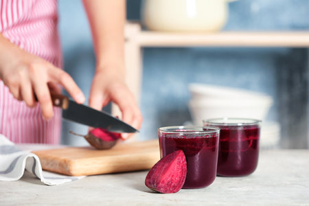 Glasses of beet smoothies and blurred woman on backgroundの写真素材