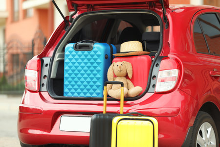 Suitcases, toy and hat in car trunk, closeupの写真素材