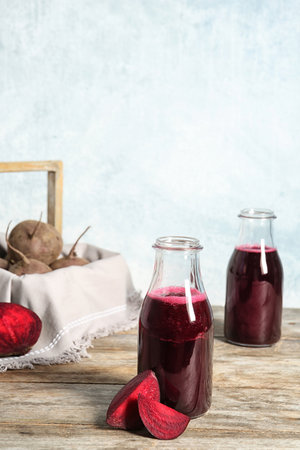 Bottle of beet smoothie on wooden table, space for textの写真素材