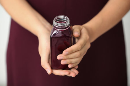Woman with bottle of beet smoothie, closeupの写真素材