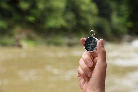 Traveler searching direction with compass in wilderness, closeup. Space for textの写真素材