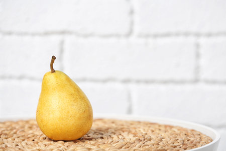 Ripe pear on table near brick wall. Space for textの写真素材