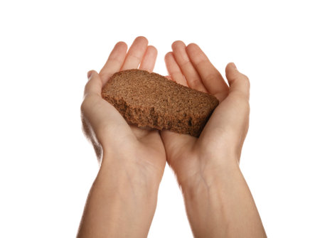 Poor woman holding piece of bread on white background, closeupの写真素材