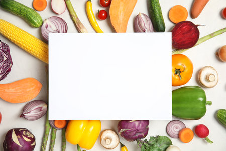 Flat lay composition with fresh vegetables and blank card for text on light backgroundの写真素材