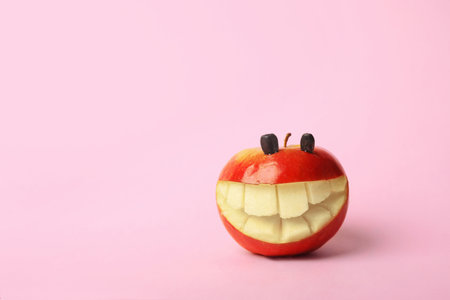 Funny smiling apple on color background. Space for textの写真素材