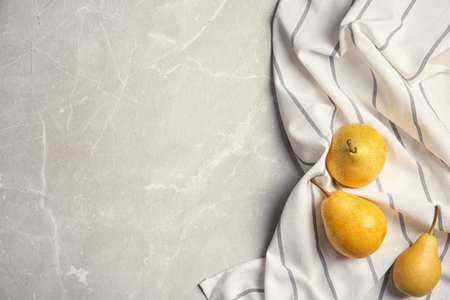Ripe pears and striped fabric on gray background, top view. Space for textの写真素材