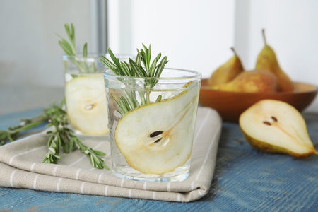 Refreshing pear cocktail with rosemary on tableの写真素材