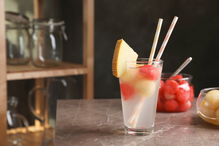 Glass with tasty melon and watermelon ball drink on tableの写真素材