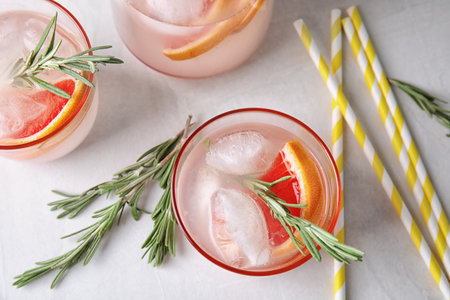 Flat lay composition with grapefruit cocktail and rosemary on gray tableの写真素材