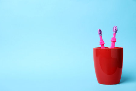 Baby toothbrushes in holder and space for text on color backgroundの写真素材