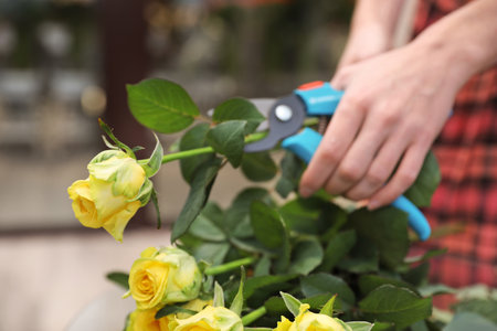 Female florist making beautiful bouquet in flower shop, closeupの写真素材