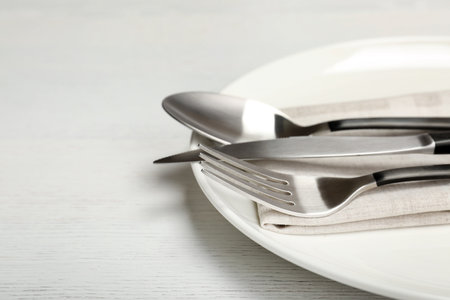 Plate with fork, knife and spoon on table, closeup. New settingの写真素材
