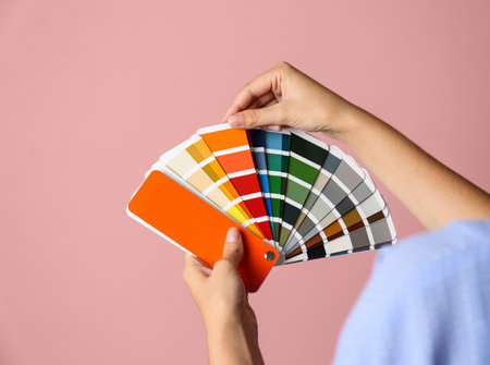 Female interior designer with palette samples on color background, closeupの写真素材