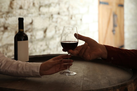 Waitress serving glass of red wine to client in restaurant, closeupの写真素材