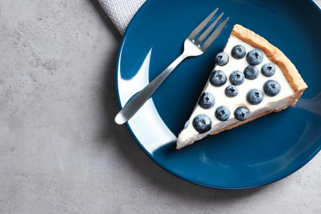 Piece of tasty blueberry cake and space for text on gray table, top viewの写真素材