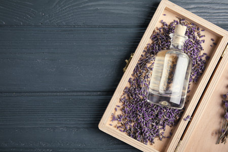 Flat lay composition with natural herbal oil and lavender flowers on wooden background. Space for textの写真素材