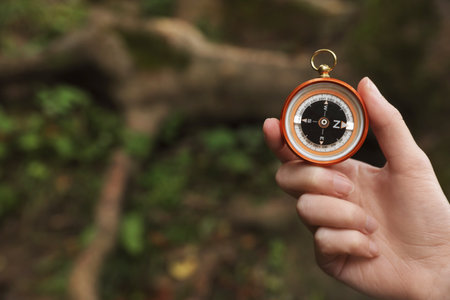 Traveler searching direction with compass in wilderness, closeup. Space for textの写真素材