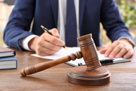 Gavel and blurred lawyer working with documents on backgroundの写真素材