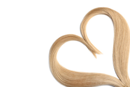 Heart made of blond hair locks on white backgroundの写真素材
