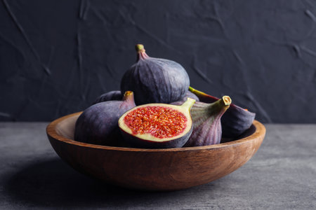 Bowl with fresh ripe figs on gray table. tropical fruitsの写真素材
