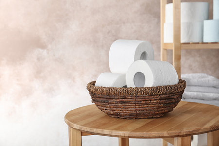 Bowl with toilet paper rolls on table indoors. Space for textの写真素材