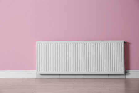 Modern radiator on color wall indoors. central heating systemの写真素材