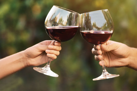 Couple with glasses of red wine outdoors, closeupの写真素材