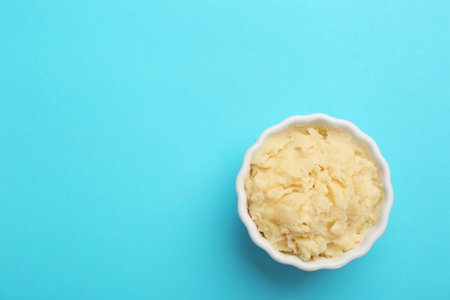 Bowl with tasty mashed potatoes and space for text on color background, top viewの写真素材