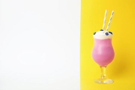 Glass of tasty milk shake and space for text on color backgroundの写真素材