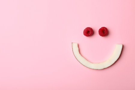 Funny flat lay composition with coconut and raspberry on color background. Space for textの写真素材