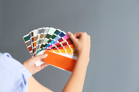 Female interior designer with palette samples on color background, closeup. Space for textの写真素材