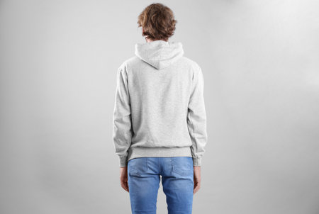 Man in hoodie sweater on light background. space for design