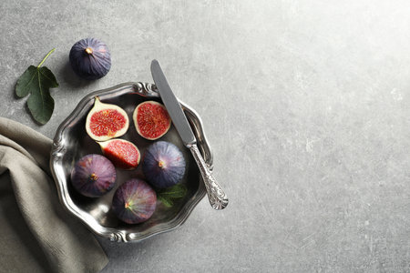 Dish with fresh ripe figs on gray background, top view. Space for textの写真素材