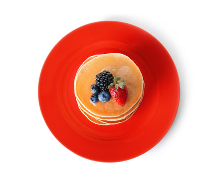 Plate with stack of tasty pancakes and fresh berries on white background, top viewの写真素材