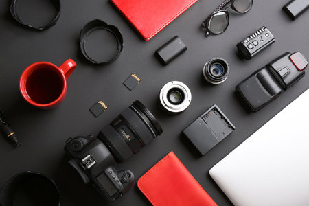 Flat lay composition with professional photographer equipment on dark backgroundの写真素材