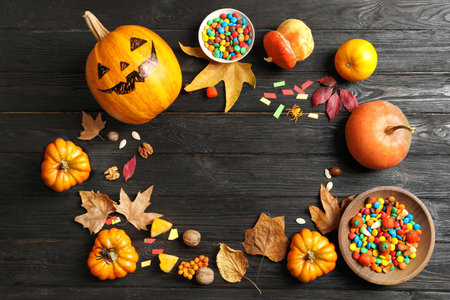 Halloween pumpkin head jack lantern and holiday decorations on wooden table, flat lay composition with space for textの写真素材