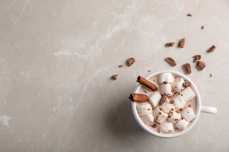 Tasty hot chocolate with milk and marshmallows in cup on table, top view. Space for textの写真素材