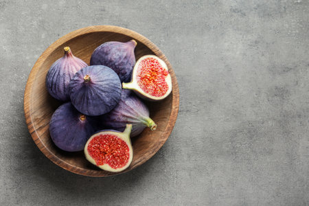Bowl with fresh ripe figs on gray background, top view. Space for textの写真素材