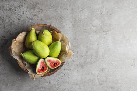 Bowl with fresh ripe figs on gray background, top viewの写真素材