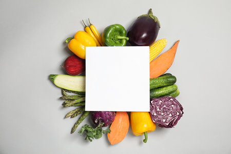 Flat lay composition with fresh vegetables and blank card for text on gray backgroundの写真素材