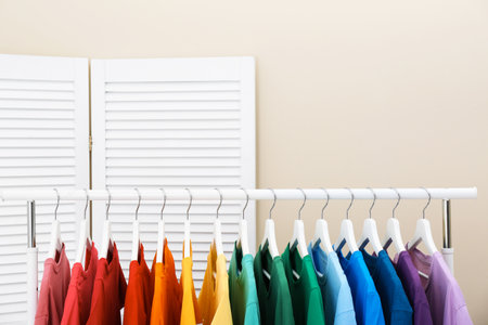Rack with bright clothes in the room. Rainbow colorsの写真素材